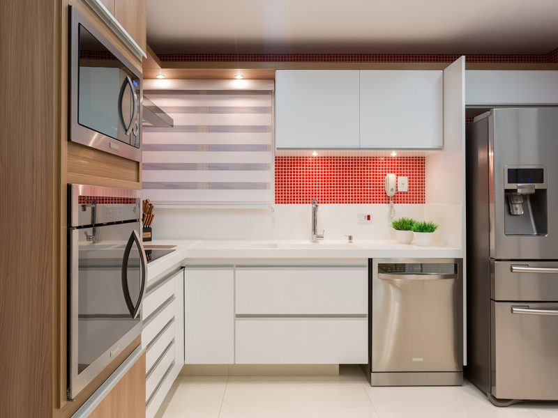 Cozinha clean, ampla em tons de vermelho e madeira
